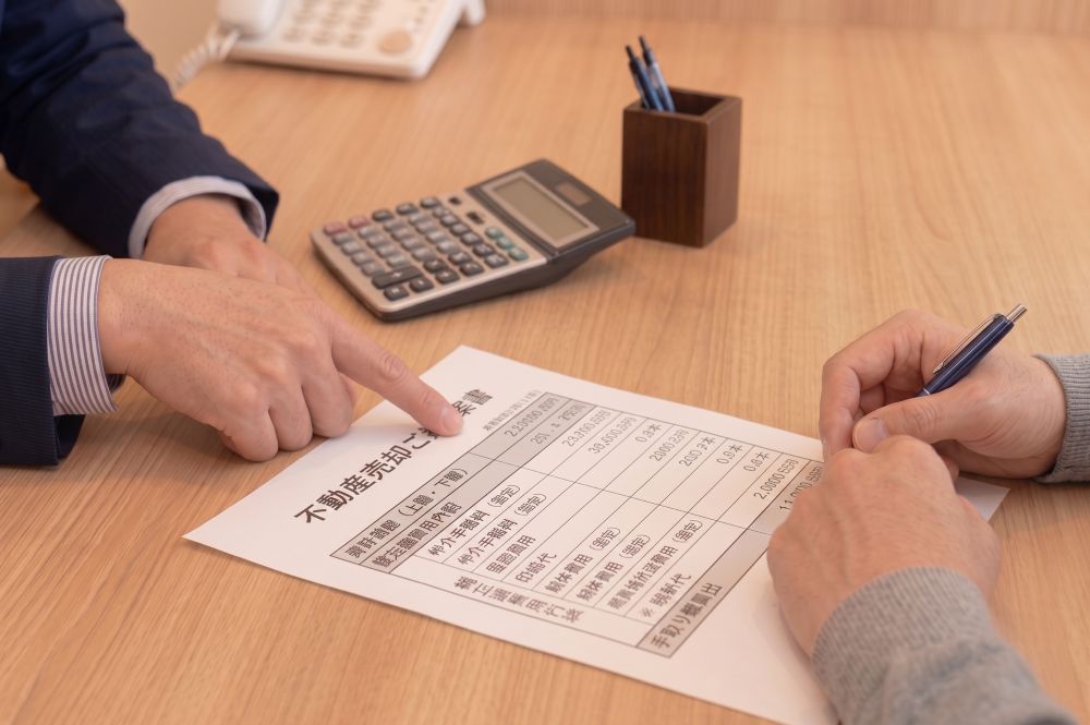 売却ご提案書を指し示して諸経費を説明する手元